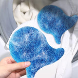 Blue indigo laundry catchers with white pet hair residue on a white garment, held by a hand